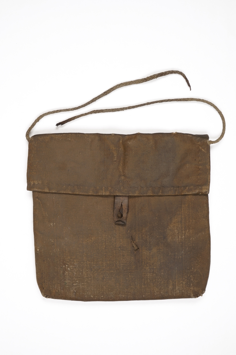 Veske av oljet seildukstekstil (i henhold til tidligere registrering), hvor lokket låses med rem av lær med knappehull og knapp av antatt tre festet på vesken.. En bærestropp av flettet tekstiltau er sydd fast i begge ender på veskens bakside. Tauet har røket.