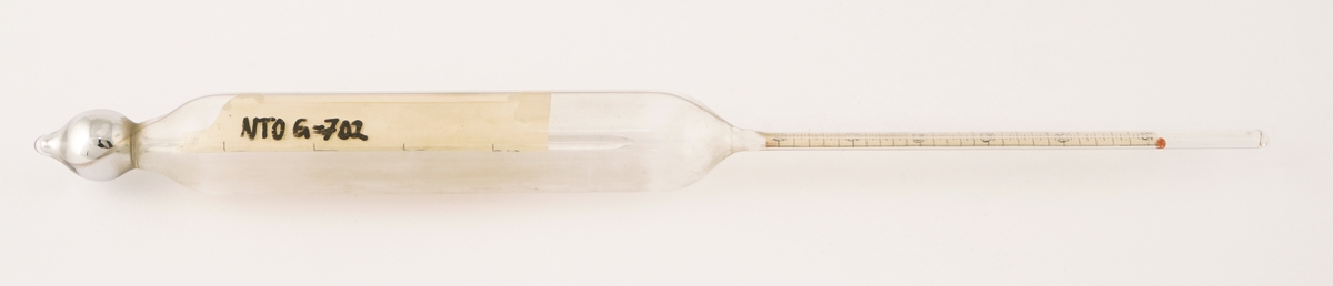 Termometer av glass  som ligger i et firkantet etui av formentlig papp.