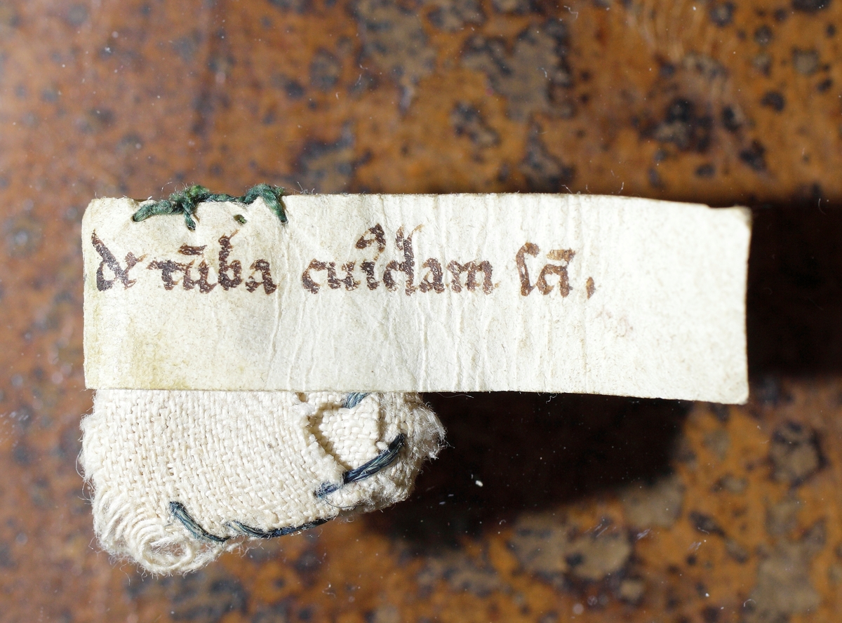 Ask gjord i bly med helgonlämningar. Dessa är tre till antalet. Två av dessa är märkta. 
På den ena står det "Unius Virginis de XV milibus".
På den andra står det "de sancto Johanne Baptiste".
Asken hittades i altaret i Hjälmseryds gamla kyrka i samband med rivningen.