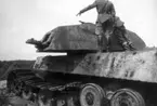 Tysk stridsvagn Kungstiger som beskjutits och analyserats på Karlsborgs provskjutningsfält 1950.
Här granskas vagnen av intresserade befäl.