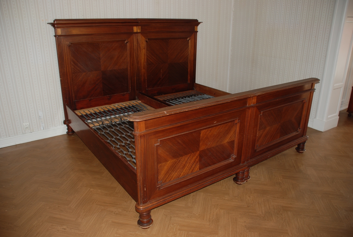 Dobbelseng som består av to enkeltsenger som står inntil hverandre. Mørkbeiset brun seng i heltre og finèr.