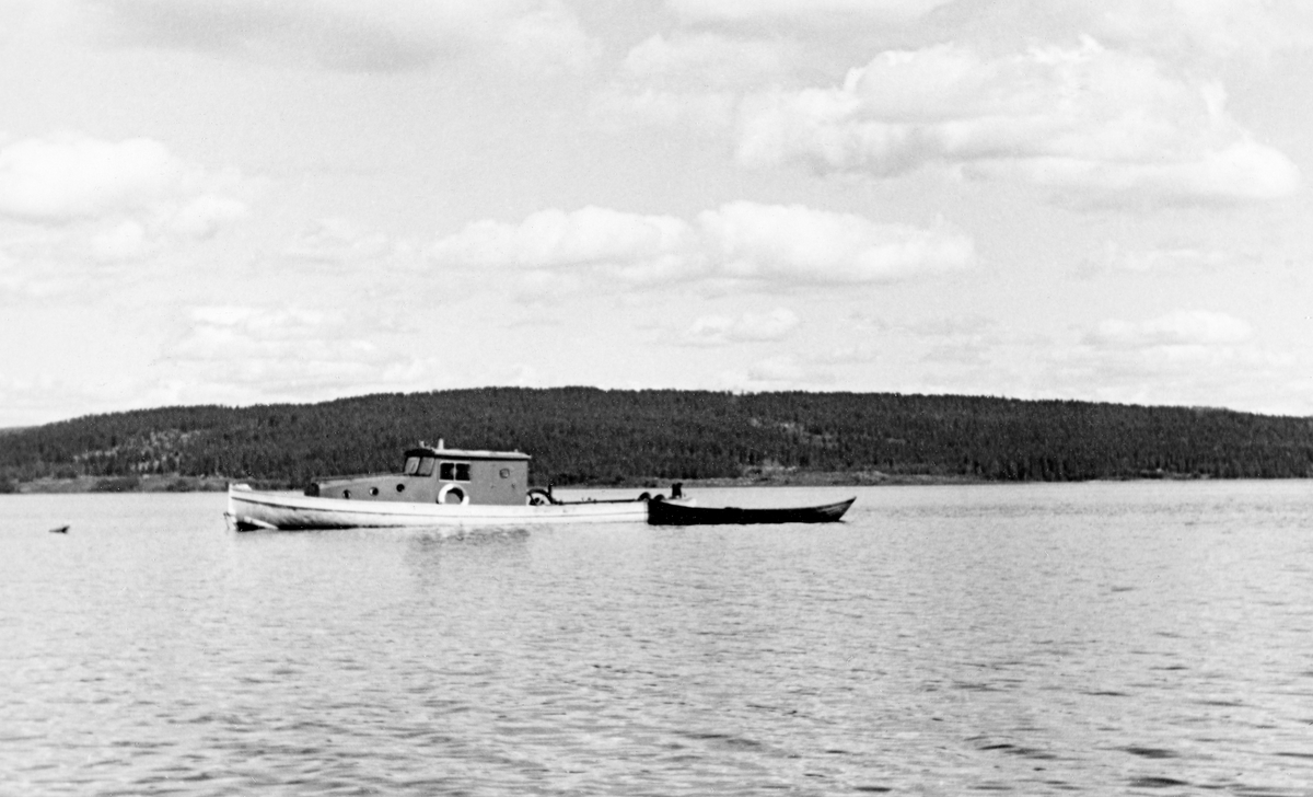 Fløterbåten «Varp I», fotografert på Storsjøen i Odalen i Hedmark med en liten lettbåt (robåt) av tre på slep. 

«Varp I» eller «VB 51» ble bygd for Christiania Tømmerdirektion i 1914.  Båten ble i hovedsak bruk på Glomma i nedre Solør og framfor alt på Storsjøen i Odalen.  Den hadde sitt opplagssted på Bukkeneset i Nord-Odal.  Der ble det opprinnelige overbygget, motoren og vinsjen fjernet like før jul i 1954 (jfr. SJF.1990-02242 og SJF.1990-02243).  Så ble skroget kjørt til Glomma fellesfløtingsforenings lenseanlegg ved Fetsund i Akershus, hvor båten ble ombygd og modernisert, før den altså ble sjøsatt ved Ullern ferjested påfølgende vår for fortsatt bruk i fløtinga i den nevnte regionen.