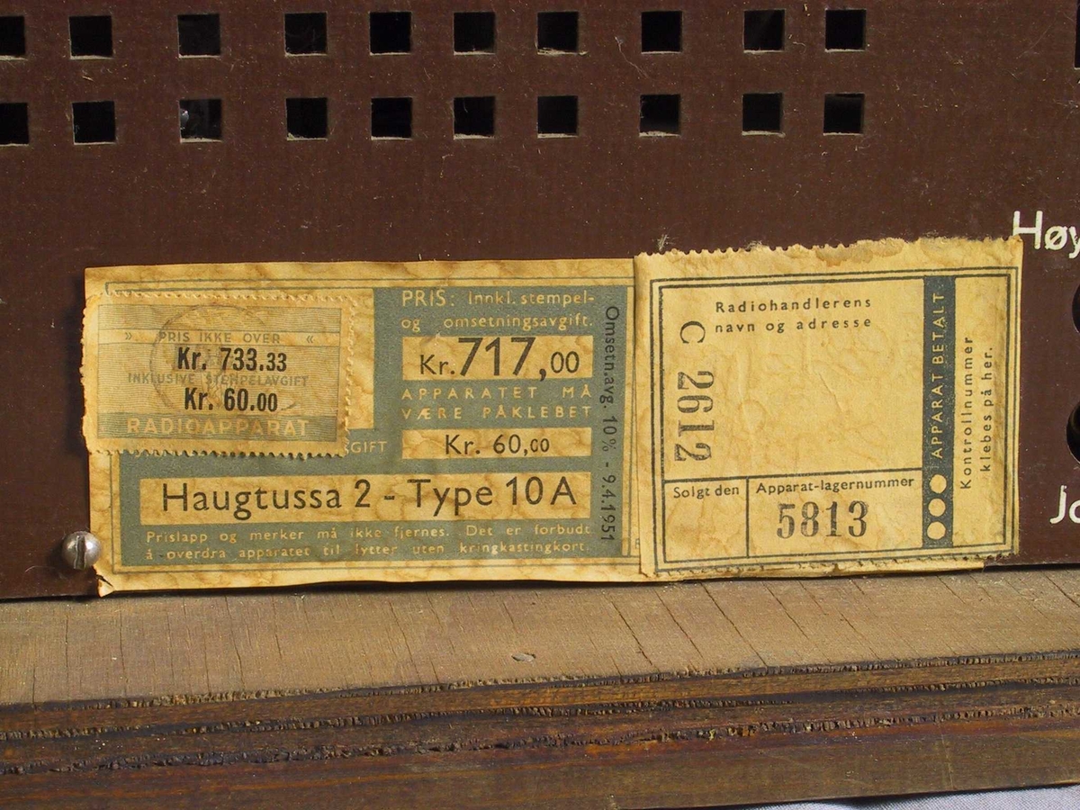 Kasse av lakkert finer, rektangulær botn. 4 store knappar framme, skala med radiostasjonar dekt av glasplate, høgtalarar bak tekstilduk.  Perforert plate (av huntonit?) bak. Svart kabel med støpsel. Litt oppskrapa lakk, avslegen flis i eine hjørnet.