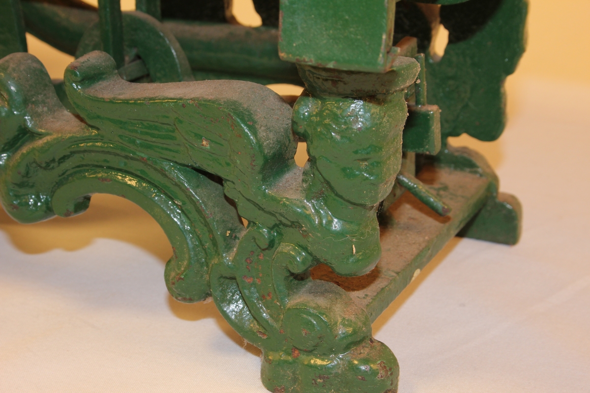 Diskvekt med to skåler. Fire føter med form av dyr-/menneskeskikkelsar. To dyrefigurar med tunger som viser når vekta er i balanse.