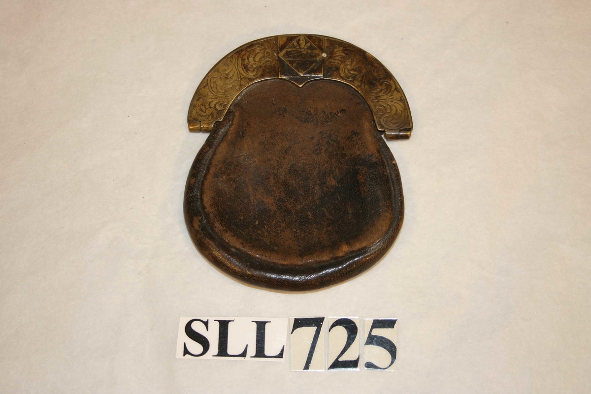 Poseforma skinnpung med messinglås og -beslag. Messing er dekorert med akantusranker.