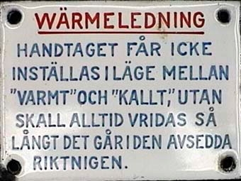 Fyrkantig skylt av emaljerad plåt med röd och blå text på vit botten:
W Ä R M E L E D N I N G
HANDTAGET  FÅR  ICKE
INSTÄLLAS I  LÄGE  MELLAN
"VARMT" OCH "KALLT", UTAN
SKALL  ALLTID  VRIDAS  SÅ
LÅNGT DET GÅR I DEN AVSEDDA
RIKTNINGEN.

Anmärkning: Jvm 11875 - 11883 har samma tema.