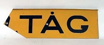 Skylt av gul reflekterande plåt med svart text:
"VARNING FÖR TÅG".
Skylten består av fyra plåtar med text och en hållare för montage i kryss.
Den gula färgen har glaspärlor som ljusreflekterande materiel.
"Krysset" har ingjutet ÖR 9183 på baksidan.
Ihopmonterat har krysset måttet bxh 560x340 mm.
Plåtarna är gråmålade på baksidan.