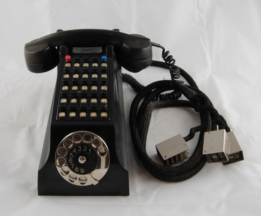 Halvautomatisk ledningstagare, även kallad "Hästhuvud" på grund av dess karakterisktiska utseende med långt "huvud". Materialet är svartflammig bakelit.

Apparaten har rader av knappar och längst fram en nummerskiva. Första raden består av röd knapp "ICL", tre svarta knappar "A", "B", "C" och blå knapp "RK". Sedan är det tjugo svarta knappar i rader om fem numrerade 1-20. Sladden delar sig i tre, med metallkontakter i ändarna, märkta I, II och III. Sladden mäter nästan två meter. Under luren står det "LM Ericsson".