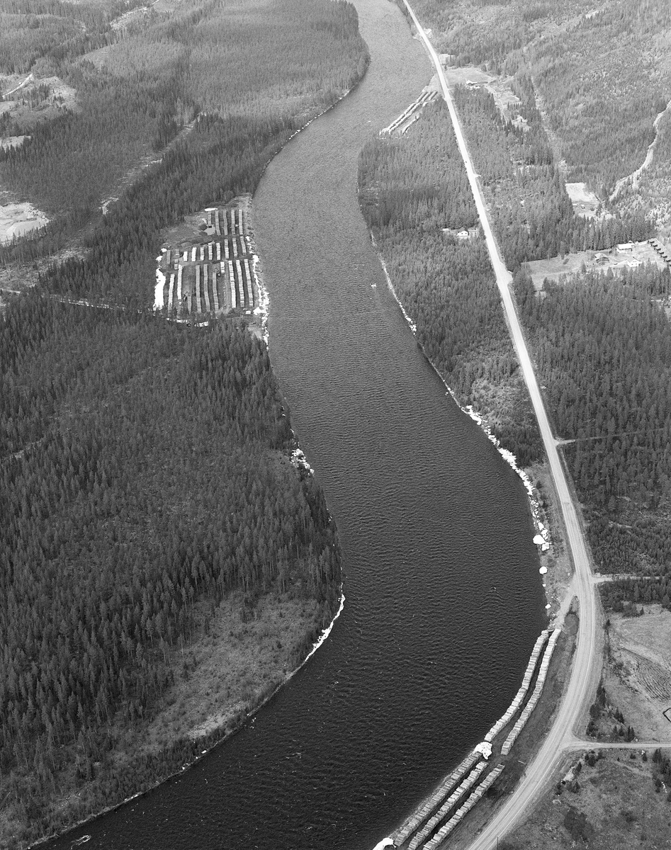 Flyfoto, tatt  over de tre velteplassene Klarälvens Flottningsförening hadde fått opparbeidet ved Trysilelva, like nord for grendesenteret i Jordet i Trysil. Hit ble slipsortimentene fra skogene omegnen transportert med lastebiler og lagt i lange lunnevrelter, hvor stokkene lå vinkelrett på vassdragets strømretning. Når vannføringa i Trysilelva ble høvelig skulle tømmeret slås på elva ved hjelp av digre griplastere. Den største av velteplassene her var Øverengvelta, som lå på vestsida av vassdraget, De to mindre veltene lå i den smale, slaktskrånende elveskråningen mellom Trysilvegen og elvebredden. 

Fra 1965 og framover fikk Klarälvens Flottningsförening opparbeidet flere terminalplasser av den typen vi ser på dette fotografiet i Trysil og Engerdal.  Slike løsninger ble mulige etter at skogsbilvegnettet i de to kommunene var blitt såpass stort at man anså det for mulig å avvikle fløtinga i de minste sidevassdragene. Omlegginga skjedde i forståelse med Trysilvassdragets skogeierforening.  Terminalplassene hadde ikke bare hjullastere, men i mange tilfeller også barkemaskiner, noe som overflødiggjorde det manuelle arbeidet med barkespader, og dermed forenklet driftsprosessene på hogstfeltene vinterstid.