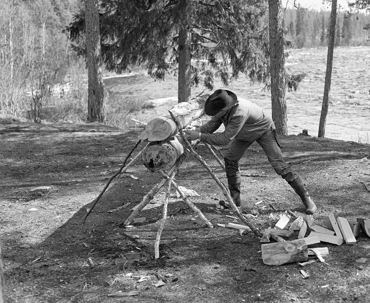 Kåre Joar Graff setter opp nying ved Stenbekkoia ved Femundselva i Engerdal i mai 1986.  Denne nyingen ble oppsatt og tent som en del av programmet da styret i Klarälvegns Flottningsförening hadde sin ekskursjon langs vassdraget dette året.  Nyinger består av en eller flere horisontalt- og paralleltliggendende stokker, lagt og nørt slik at de skal gi god og vedvarende varme.  Slik ild ble brukt i skog og utmark.  Vinterstid overnattet skogsarbeiderne vanligvis i hus – skogstuer eller koier – med mildt sagt enkel standard.  Men i vårsesongen forekom det ikke sjelden at fløterne sov under åpen himmel og hentet varme og tørk fra nyinger. I en medisinalberetning fra 1871 beskrev distriktslege Christian Pavels Munthe (1816-1884) i Elverum nyingen slik:

«Ikke altid kunne de vaade og forfrosne Flødere finde varmt og beboet Hus til Natten, - ikke engang en Køie, hvor de kunne tørre sine Klæder og finde et varmt Leie.  Meget ofte maa de lægge sig vaade som de ere paa den vaade Jord med et Lag af Barkviste under sig, efterat have opgjort en Ild  - «Nying» - paa følgende Maade: De tage en tyk, letbrændelig Stok, hvorover de lægge en anden noget mindre af samme Slags.  Disse to Stokke holdes fra hinanden ved to eller flere Stykker Træ ved Enderne («Beitkøler»), medens den øverste hindres fra at falde ned ved paa hver Ende at støttes ved tvende længere Kabber, der som Strævere lægges på imod den.  En saadan Kabbe kaldes «Haldmær» og mellem de saaledes ovenpaa hinanden liggende Stokke opgjøres paa flere Steder Ild, der langsomt brænder og underholde Varme den hele Nat.  Fløderne lægge sig nu paa begge Sider af en saadan «Nying», og vende sig gjentagne Gange om Natten, for at snart den ene, snart den anden Side kan blive varmet og tørret ved Ilden.»

Nyingene kunne lages av en eller flere stokker, og var det flere enn to, ble de ofte lagt slik at nyingen fikk et pyramidalt tverrsnitt.  I dette tilfellet var det en to-stokknying, der den underste stokken sto på et trefotet stativ av kjepper.  Oversida av denne stokken og undersida av overstokken var fliset opp ved hjelp av ei øks, og i mellomrommet mellom dem lå det tørre flister, som skulle gjøre det lettere å tenne ildstedet.  Den øverste stokken var støttet med skråstivere av kjepper på begge sider.  Da dette fotografiet ble tatt var arbeidsformann Kåre Joar Graff i ferd med å legge tørr opptenningsflis mellom nyingsstokkene.