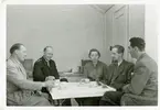 Bilden visar ett fikabord på Basareholmen. Runt bordet sitter från vänster; verkmästare Herbert Karlström, styrman Erik Renud (chef för verksamheten), kontorist Sussie Svensson och två okända män.