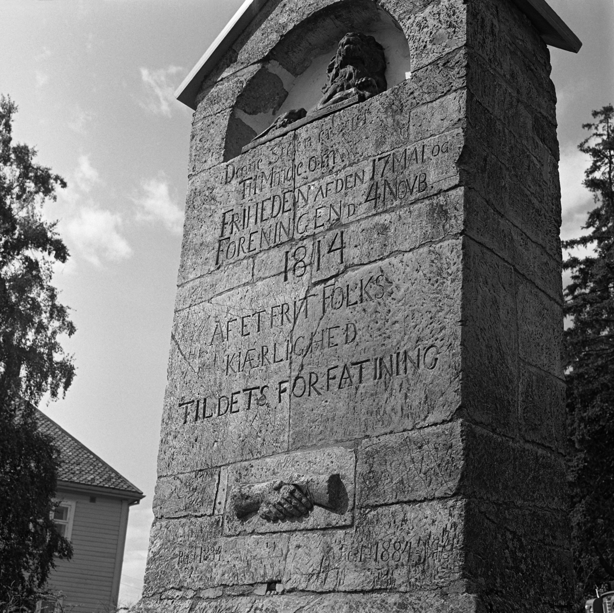 Minnestøtte knyttet til den norske atskillelsen fra Danmark, vedtaket om en egen norsk konsitusjon og den påfølgende foreninga med Sverige.  Støtta er murt av kvaderstein, og den har et lite saltak av skifterheller på toppen.  Under dette taket er det ei lita, halvsirkelformet nisje hvor det er lagt en figur som antakelig skal forestille riksløven.  Under denne nisja er følgende tekst innhogd i steinen: «Denne Steen er reist Til Minde om FRIHEDEN AF DEN 17. MAI OG FORENINGEN D. 4. NOVB 1814 AF ET FRIT FOLKS KJÆRLIGHED TIL DETS FORFATNING».  Under denne teksten er det innmontert et steinrelieff med to hender som møtes i et håndtrykk.  Under dette igjen synes det å være gjort forsøk på tilføyelser.  Vi skimter blant annet årstallene 1834 og 1884, som altså var jubileumsår.  I bakgrunnen til venstre skimtes hjørnet av et våningshus med krumsteinstekket tak. 

Dette fotografiet er tatt i samband med en befaring i kanalbyggeren Engebret Soots hjemtrakter i 1978.  Teksten på støtte må forstås i lys av at den er reist i et lokalsamfunn der avstanden til svenskegrensa er kort, og hvor den nye unionen med Sverige etter at Norge hadde fått sin egen grunnlov innebar et lavere militært spenningsnivå enn det man hadde hatt i dansketida. 