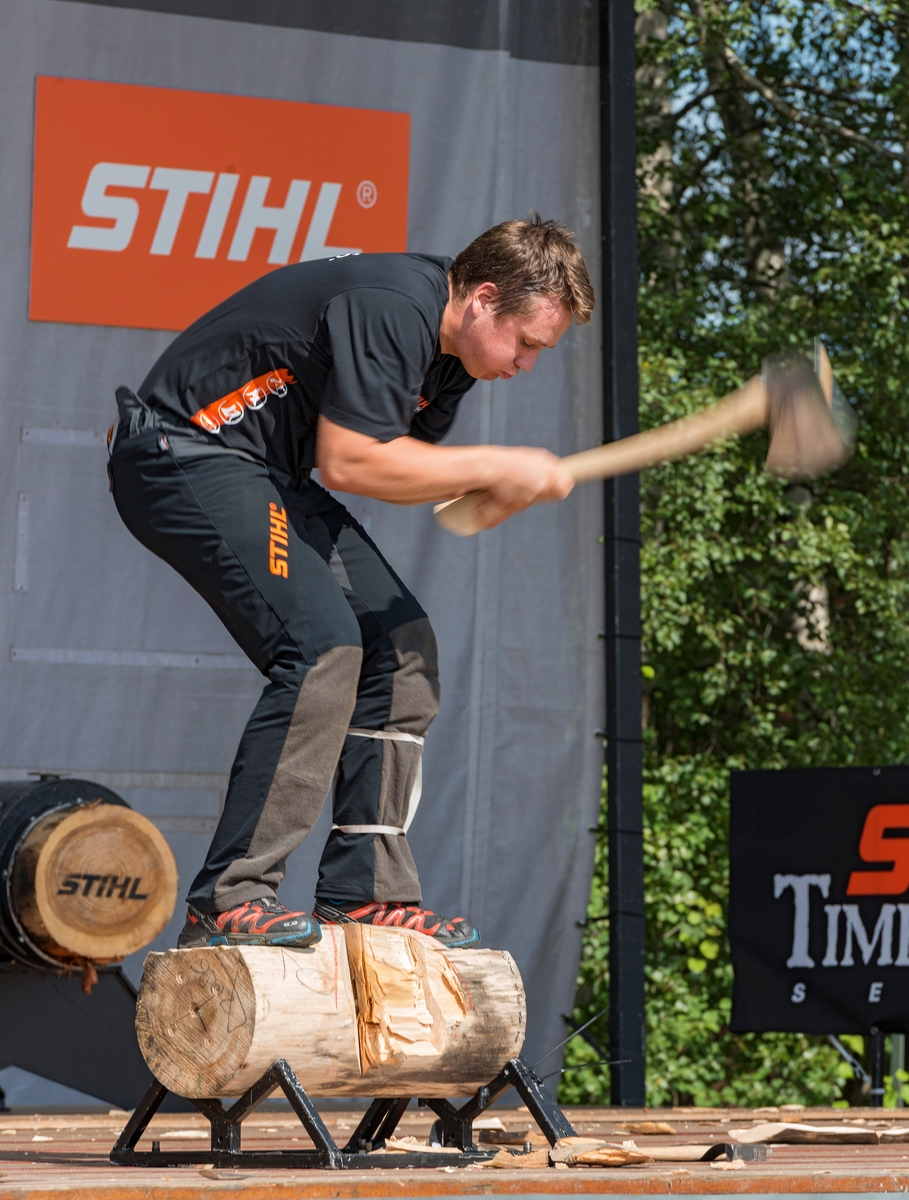 Fra nordisk mesterskap i «Stihl timbersports» under De nordiske jakt- og fiskedager på Norsk Skogmuseum i Elverum torsdag 7. august 2014.  Her arrangerte skogsredskapsprodusenten Stihl konkurranser, der deltakernes hurtighet og presisjon i arbeid med øks, stokksag og motorsag ble bedømt og premiert.  2014 var det første året denne konkurransen var lagt til Norsk Skogmuseum og De nordiske jakt- og fiskedager.  Da dette fotografiet ble tatt var en av deltakerne i ferd med å dele en kabbe som han sjøl sto på ved hjelp av øks, en øvelse der tidsfaktoren var viktig i forhold til konkurrenter som kappet andre kabber med samme dimensjon med samme redskap.  En jury fra arrangørenes stab kåret for øvrig aktivitetene på Stihls scene til «Årets event» med følgende begrunnelse: «Formidler kunnskap om tradisjonelle teknikker i en moderne og underholdende form.  Stor publikumsappell med spektakulært show. »

«Stihl timbersports» er en internasjonal konkurranse for tømmerhoggere. Den har sitt utspring i Canada, USA og New Zeeland, der skogsarbeidere arrangerte lokale konkurranser for å kåre den beste blant dem. Med tida ble det utviklet tester for vurdering av styrke og ferdighet i konkurranser på høyt nivå med profesjonelle aktører. I 1985 stiftet STIHL Inc. USA, i samarbeid med sportskanalen ESPN, det som ble «Stihl timbersports series», som er en konkurranseserie i USA og Europa.  2014 var det første året slike konkurranser ble avviklet i Norge. 