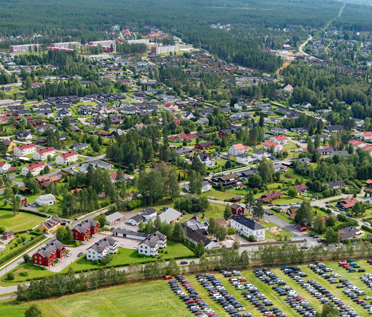 Boligområdene sør for Elverum sentrum, fotografert fra lufta en augustdag i 2014.  Bildet er tatt fra en posisjon litt nord for Norsk Skogmuseum, og med kameraet vendt østover.  I forgrunnen ser vi at jordet sør for tunet på Elverum prestegard brukes som parkeringsplass, noe som gjøres i forbindelse med arrangementet De nordiske jakt- og fiskedager på museet andre weekend i august hvert år.  Til høyre for den søndre delen av Storgata, som går på tvers av bildet i forgrunnen, ser vi boligområder som stort sett er utbygd etter 2. verdenskrig.  Unntaket er «Kirkenær» - den kvitmalte bygningen med svart valmtak og bakenforliggende rødmalt stabbur – som ligger mot Storgata, litt til høyre i forgrunnen.   Denne eiendommen var fra 1850-åra og framover embetsbolig for sorenskriveren i Sør-Østerdalen.  Villaområdene bakenfor kalles Gårderløkka og Fjellsetlia.  Lengst til venstre i bakgrunnen skimter vi også blokkbebyggelse, som antakelig er bygd i regi av Elverum tomteselskap.