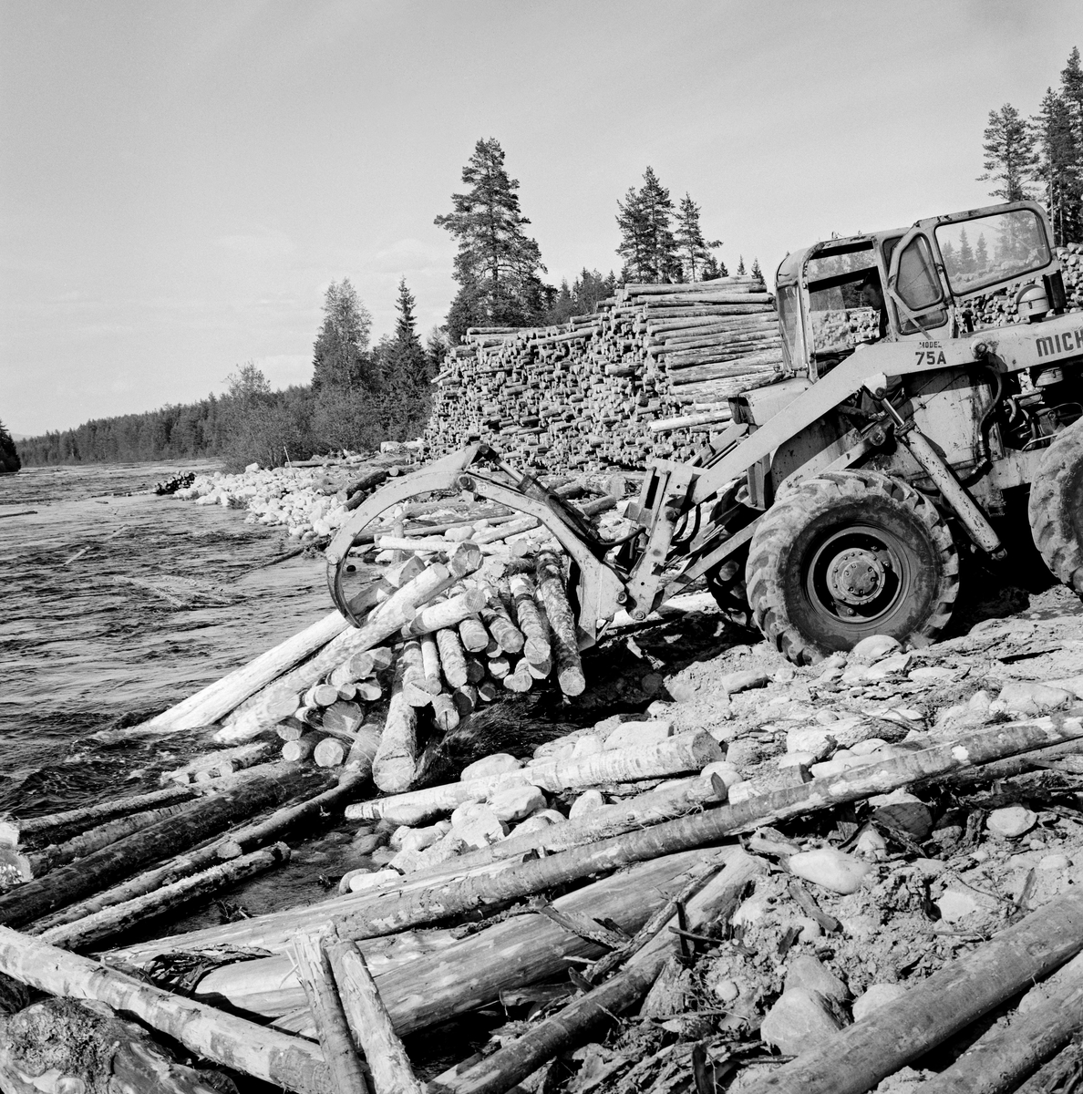 Utislag av maskinbarket slipvirke (cellulosetømmer) ved hjelp av anleggsmaskin med gripeklo fra en velteplass ved en elvebredd langs elva Flisa, ei elv som renner gjennom Våler og Åsnes kommuner i Hedmark.  Fotografiet er tatt idet maskinføreren slapp en del tømmer han hadde hentet fra en bakenforliggende velteplass i vannet ved elvebredden.  Dette var tømmer som var hentet langs skogsbilveger i omkringliggende skoger med tømmerbiler og samlet på dette stedet for maskinelt utislag, muligens også maskinell barking.

I 1960-åra ble det bygd terminalplasser med barkemaskiner ved flere av de store fløtingselvene i Norge.  På disse plassene samlet man tømmer som var framkjørt ved hjelp av tømmerbiler på de mange skogbilvegene som var bygd i etterkrigsåra.  På denne måten kunne en unngå den mannskaps- og kostnadskrevende fløtinga på de minste vassdragene.   I 1966 ble det dessuten inngått en avtale mellom Glommen Cellulosetømmerkjøperes forening, skogeierforeningene for regionene som soknet til Glomma- og Mjøsvassdragene og Glomma fellesfløtingsforening om at det skulle installeres barkemaskiner på flere terminalplasser.  Teknisk konsulent Carl Fredrik Lindeman i Glommen skogeierforening mente at det burde etableres slike plasser med maksimum 25 kilometers innbyrdes avstand oppover langs Glomma.  Det ble etter hvert 42 terminalplasser med barkeanlegg.  De sparte skogsarbeiderne for den manuelle barkinga, som i streng vinterkulde kostet dem mye tid og krefter.  For skogeierne innebar bruken av terminalplasser for tømmer at de slapp floring og utislag.  Terminalplassene muliggjorde dermed rasjonalisering av så vel skogsarbeid som tømmertransport. Fløting av tømmer. Skogbruk.