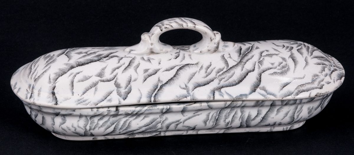 Tvättservis av vitt porslin med marmorering i grått. Servisen består av handfat, potta, en avlång tvålkopp och en kvadratisk, båda med lock. Handfatet stämplat Gustafsberg.