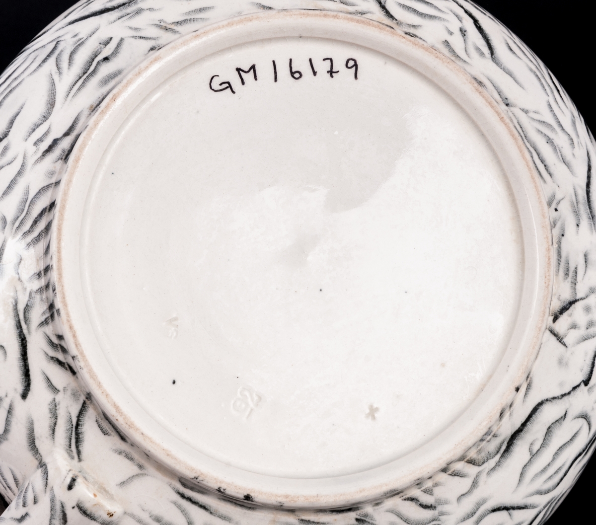 Tvättservis av vitt porslin med marmorering i grått. Servisen består av handfat, potta, en avlång tvålkopp och en kvadratisk, båda med lock. Handfatet stämplat Gustafsberg.