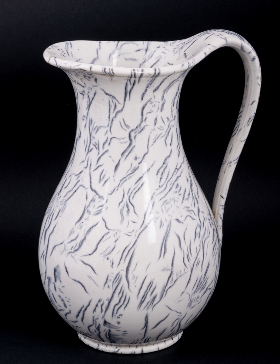 Tvättservis av vitt porslin med marmorering i grått. Servisen består av handfat, potta, en avlång tvålkopp och en kvadratisk, båda med lock. Handfatet stämplat Gustafsberg.