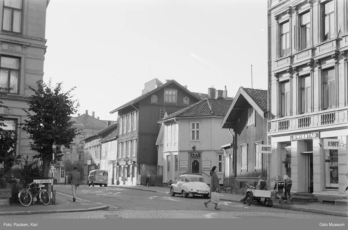 gateløp, trehusbebyggelse, bygårder, biler, mennesker, varemotorsykkel