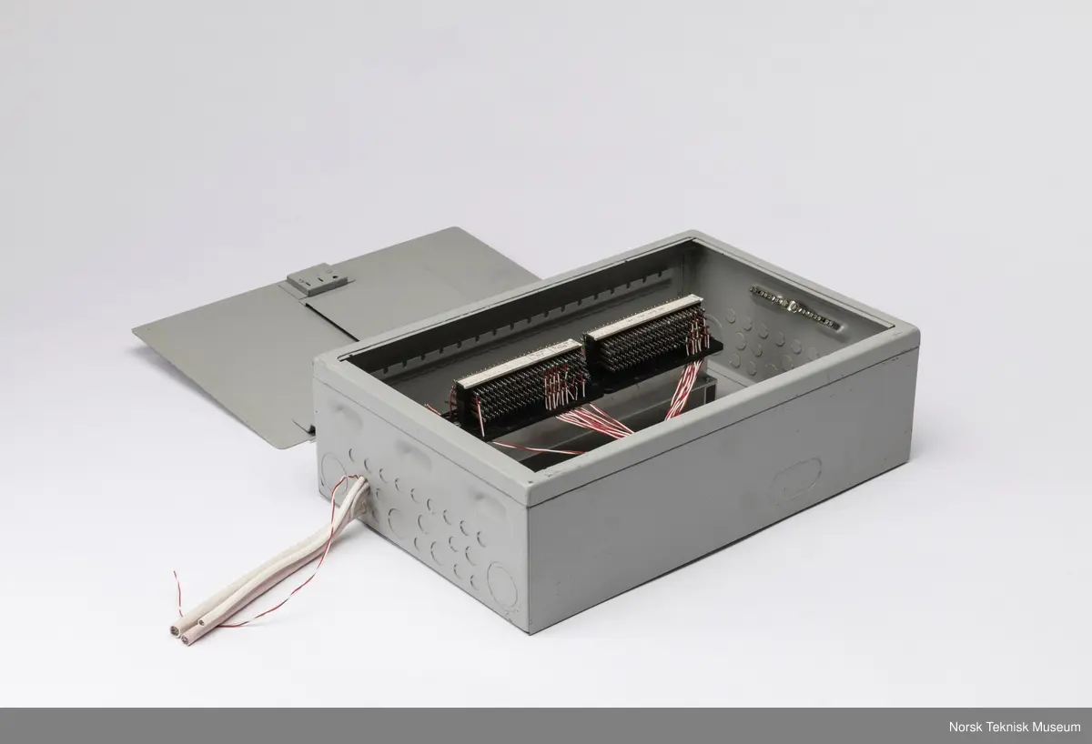 Sikringsskap med løse skruer oppi hvit skumgummi inni skapet og ledninger stikkende ut.