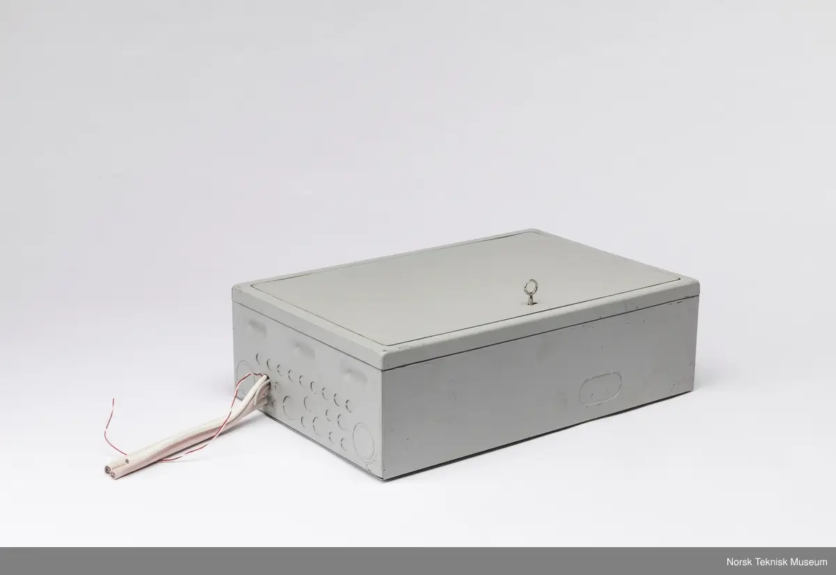 Sikringsskap med løse skruer oppi hvit skumgummi inni skapet og ledninger stikkende ut.