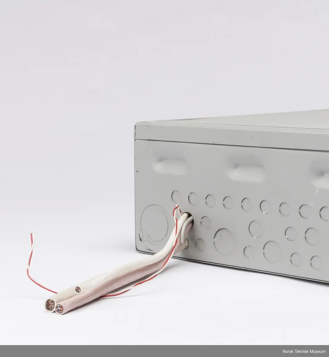 Sikringsskap med løse skruer oppi hvit skumgummi inni skapet og ledninger stikkende ut.