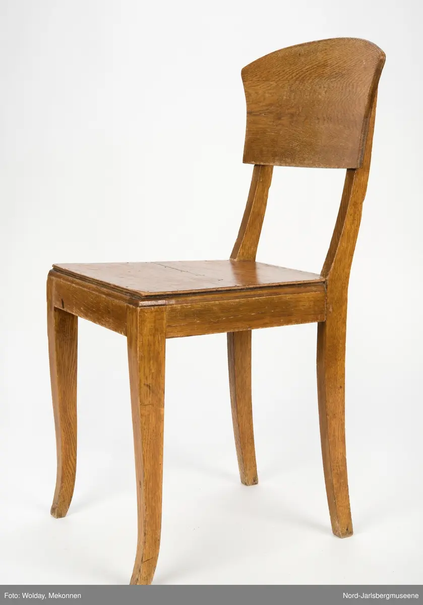 Enkel stol i lakkert finer, uten armledner. Ryggstøplaten med en fint buet overkant.