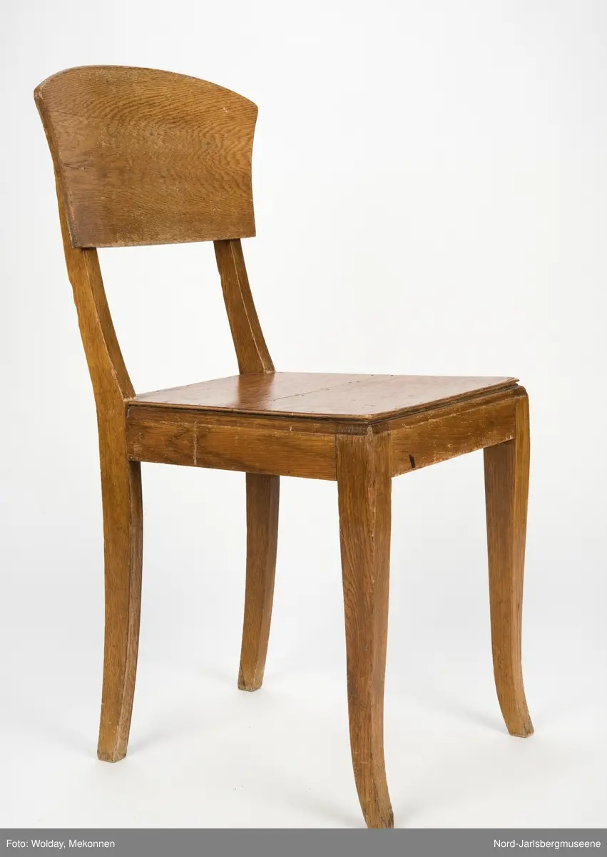 Enkel stol i lakkert finer, uten armledner. Ryggstøplaten med en fint buet overkant.