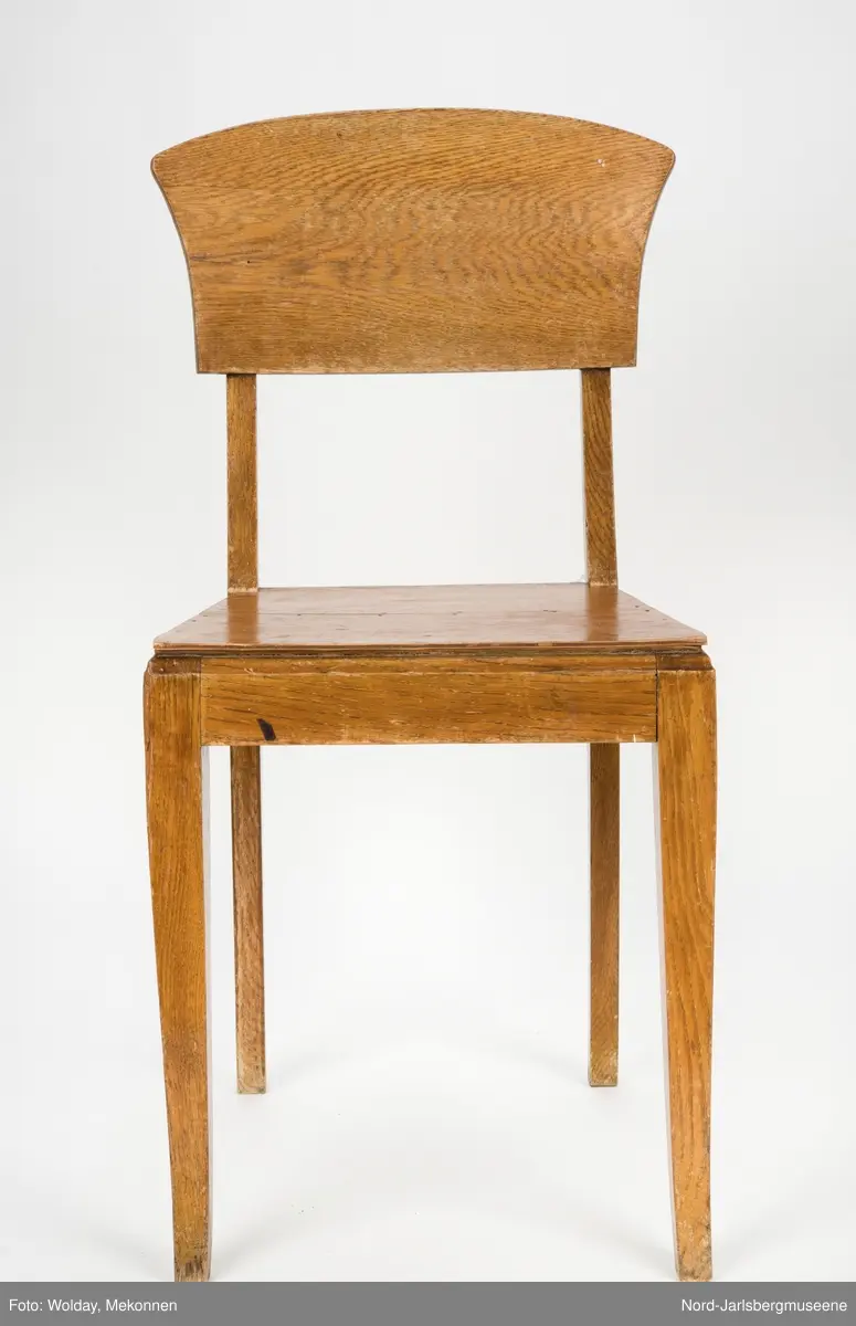 Enkel stol i lakkert finer, uten armledner. Ryggstøplaten med en fint buet overkant.