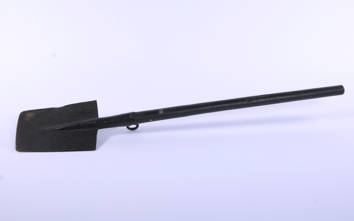 Langt, rett skaft stukket gjennom falen, ender i et spor på spadens iunderside. rett, trapesformet blad. Kraftig krok på skaftets underside, ved falen.
3 uidentifiserte stempler på bladets overside, mulig en kronet C (?)