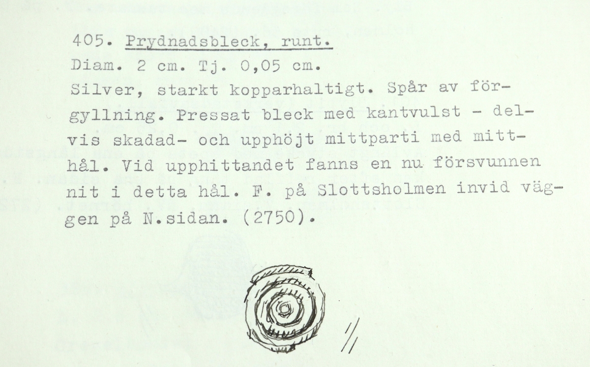 Runt prydnadsbleck av starkt kopparhaltigt silver, med spår av förgyllning. Pressat med delvis skadad kantvulst och upphöjt mittparti med mitthål. Vid upphittandet fanns en nu försvunnen nit i detta hål.