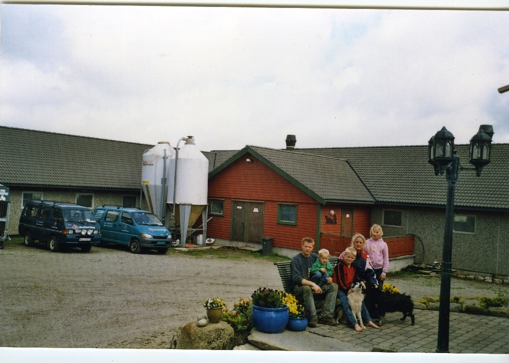 Familien på tunet i 2005 på bnr. 4 på Skrudland. Frå v. Alfred Skrudland (25.9.1969 - ), Vegard Skrudland (25.3.2001 - ), Anders Skrudland (23.7.1996 - ), Nina Kari Skrudland f. Tjelta (29.8.1973 - ) og Camilla Skrudland (26.9.1994 - ). Hunden heiter "Lady".