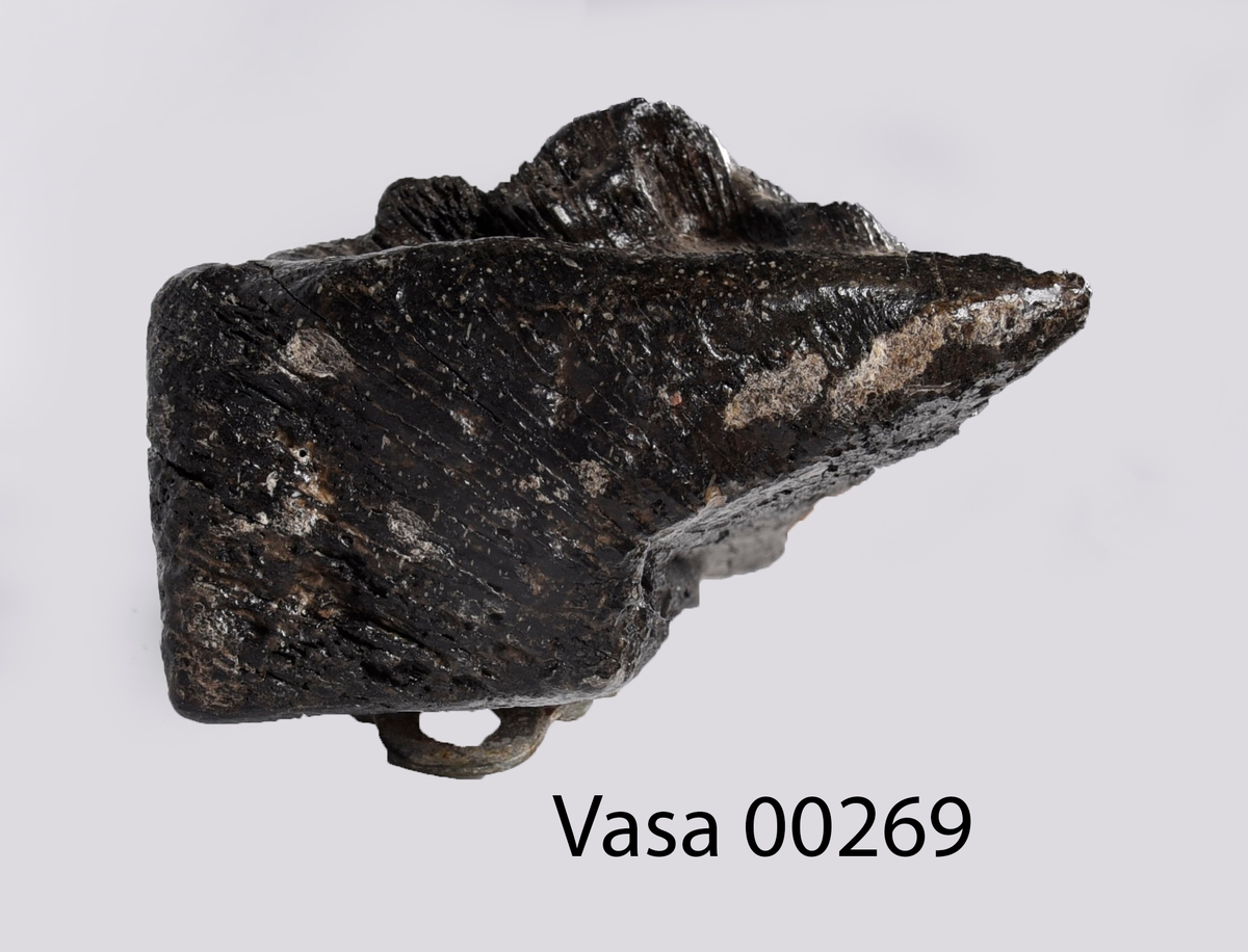 Skulpterad pilaster föreställande en herm eller möjligtvis en karyatid, under jonisk kapitäl.
Huvudet är vridet åt vänster samt prytt med en krona. Armarna hålls sträckta utefter sidorna.
Kroppen övergår i det med blad- och blomornamentik rikt sirade pilasterskaftet som smalnar av nedåt. Skaftet avgränsas genom en enkel vulst eller list från den rikt sirade och mjukt utbuktande piedestalen. Nedtill är piedestalen försedd med en bred bas. Skulpturens baksidan är slät.
Skulpturen är sliten.

Text in English: Sculptered pilaster with a Herm, or possibly a Caryatid, beneath an Ionic capital.
The head, with a crown, is turned to the left. The arms are streched out along the sides.
The body extends into the shaft of the pilaster, which tapers downwards and is richly decorated with leaf and flower ornamentation. A simple torus or batten separates the shaft from the richly decorated, softly bulging pedestal that has a broad base. The back of the sculpture is smooth.
The sculpture is worn.