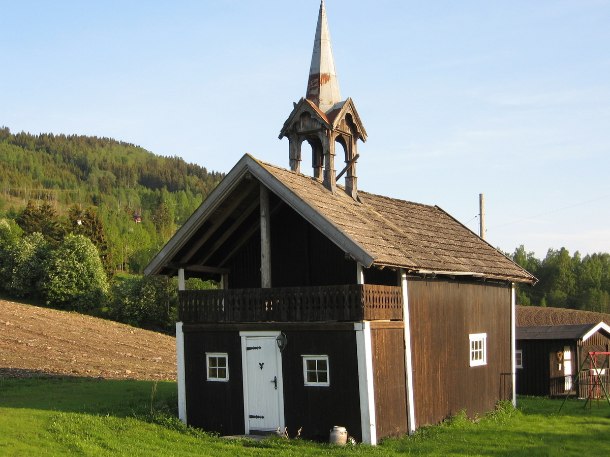 Klokketårnet på Ødegården. Kryssformet saltak og kjegleformet midtparti.