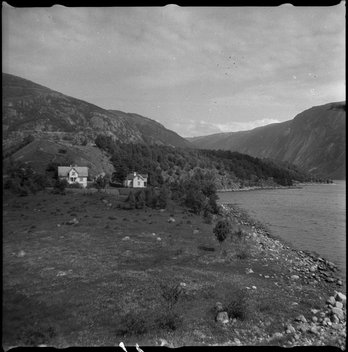 Bilder av familien Skjold fra Sauda i en hage og Oddvar Skjold som gutt på tur ved flere hytter og jettegryter i fjellet.