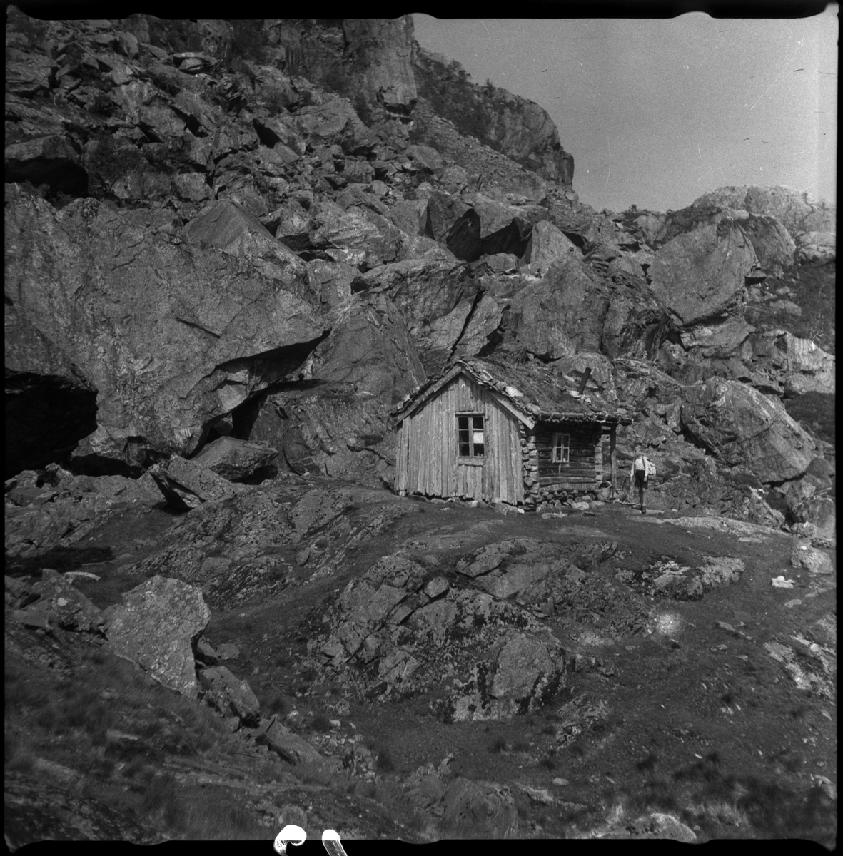 Bilder av familien Skjold fra Sauda i en hage og Oddvar Skjold som gutt på tur ved flere hytter og jettegryter i fjellet.