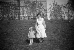 Vårdarinnan Karin Hasselberg håller ett litet barn i handen.