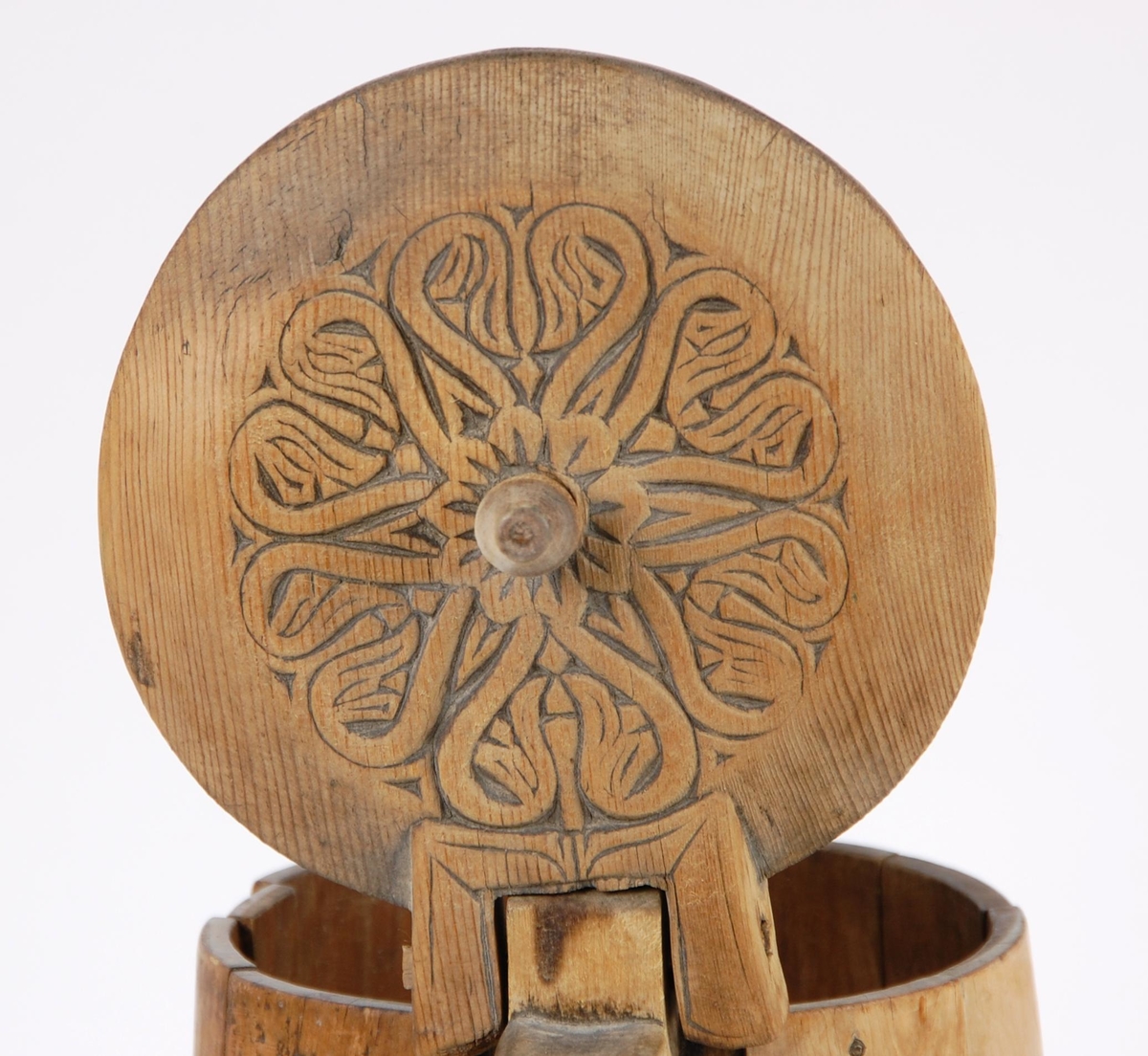 Kanne av trestaver. Lokket med seks hjerteformete utskjæringer. Lokkgrep kuleformet med flat topp. Korpus med syv gjorder oppe og åtte nede. Hanken skåret ut av en stav.