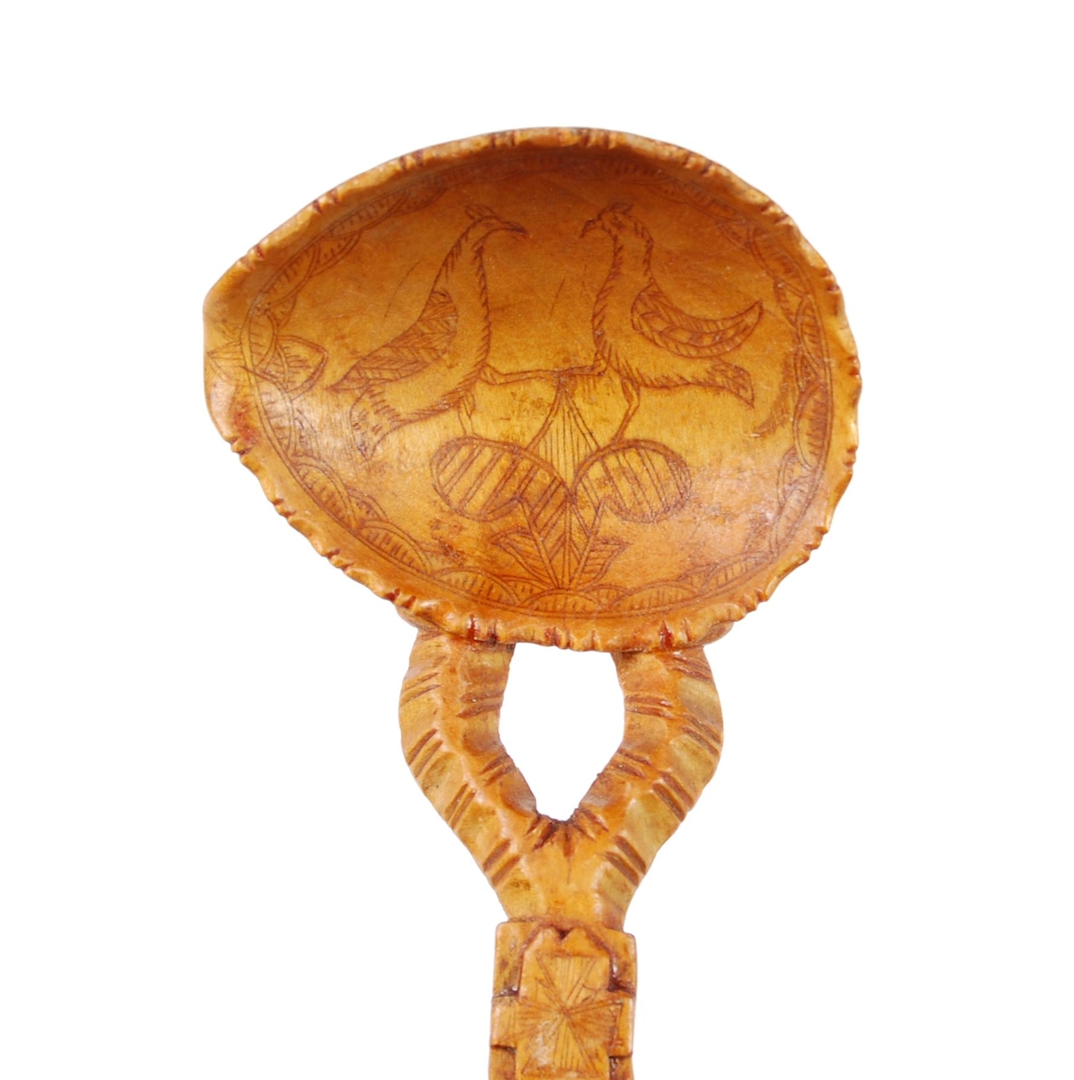 Skje av bjørk. Ovalt skjeblad med åpen tut på den enesiden, profilert langs kanten, kolrosingdekor på oversiden med bl.a. fuglemotiver og blomst, undersiden har kolrosingsdekor av blomster Halsen todelt. Skaftet har kolrosingdekor både på over- og undersiden, ender i en spiss.