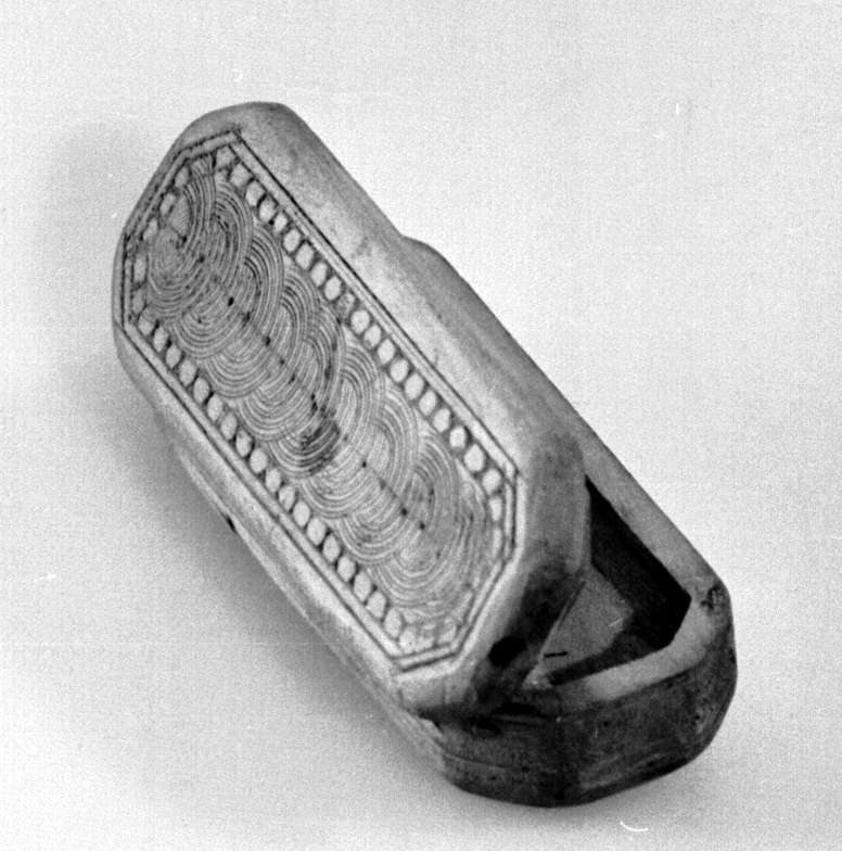 Eske av tre, med innrissinger. Motiv av perlerad og sirkler på lokk, sidene og undersiden av esken. 

Blekkflekker på lokk og korpus.