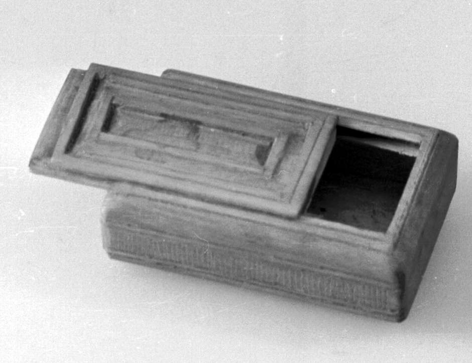 Eske av tre, med skyvelokk. Lokk og underside av eske er dekorativ utformet med treskjæring.