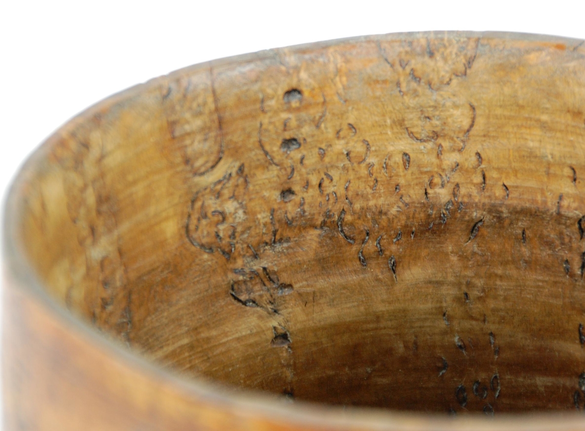 Kanne av dreid valbjørk. Lokket med uskåret springende løve omgitt av bård, bølgete utskjæringer langs kanten. Lokkåpner formet som en løve. Hanken med skjæringer langs kanten, ender i en spiss. Tre liggende løver danner føttene. Buemerke under.