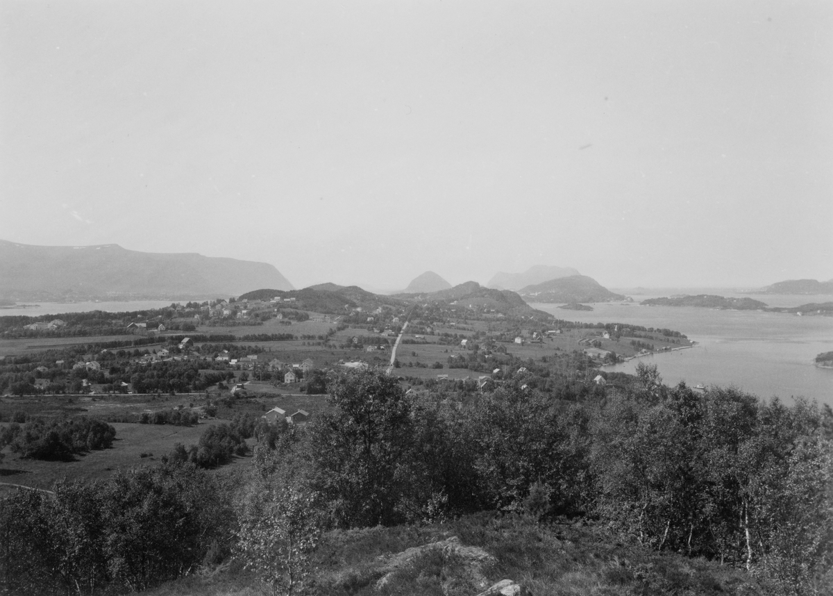 Prospektfotografi av flere gårsanlegg og boliger i Breivika, sett mot vest fra Holsfjellet.