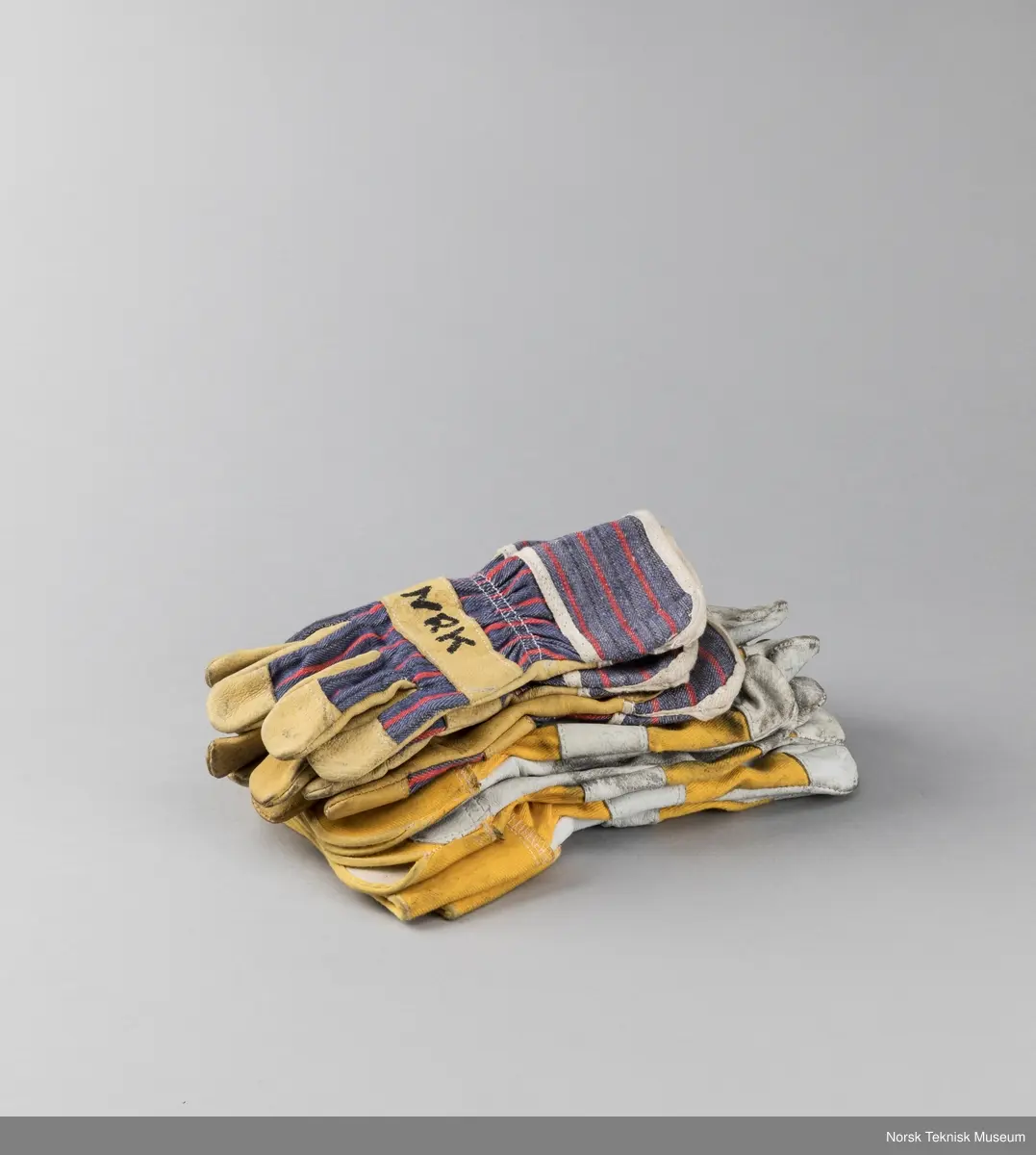 Fire par arbeidshansker hvorav ett av parene mangler høyre hånd.