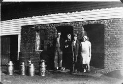 Tenestejenter og drenger framfor brunnhusdøra i den gamle lø