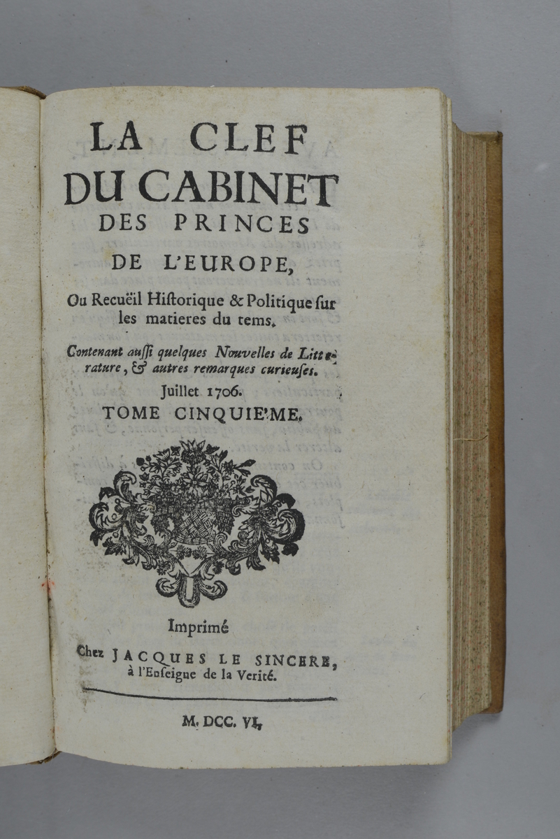 Bok, helfranskt band "La clef du cabinet des princes de l´Europe", del 5, tryckt 1706.
Skinnband med blindpressad och guldornerad rygg i fem upphöjda bind, titelfält med blindpressad titel, fält med volymens nummer och tryckår, fält med ägarens initialer samt påklistrad pappersetikett. Med stänkt snitt.