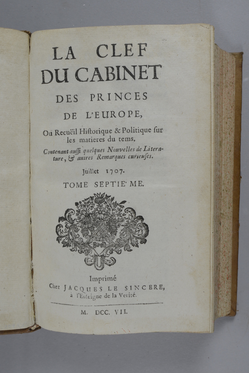 Bok, helfranskt band "La clef du cabinet des princes de l´Europe", del 6, tryckt 1707.
Skinnband med blindpressad och guldornerad rygg i fem upphöjda bind, titelfält med blindpressad titel, fält med volymens nummer och tryckår, fält med ägarens initialer samt påklistrad pappersetikett. Med stänkt snitt.