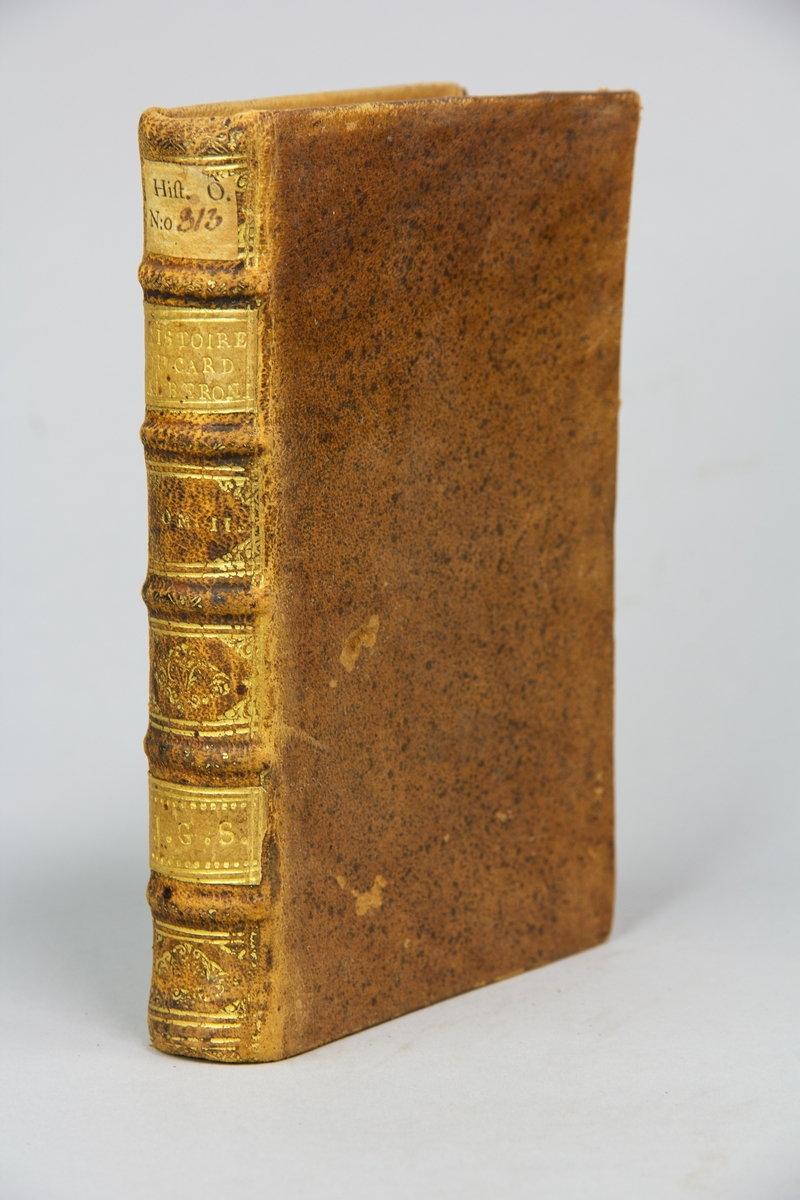 Bok, helfranskt band, "Histoire du cardinal Alberoni, et de son ministère. Jusqu'à la fin de l'année 1719. Par Mr. J.R**" del II, utgiven i Haag 1720.

Skinnband med blindpressad och guldornerad rygg i fem upphöjda bind, titelfält med blindpressad titel, fält med volymens nummer och ett fält med ägarens initialer samt påklistrad pappersetikett. Med stänkt snitt.