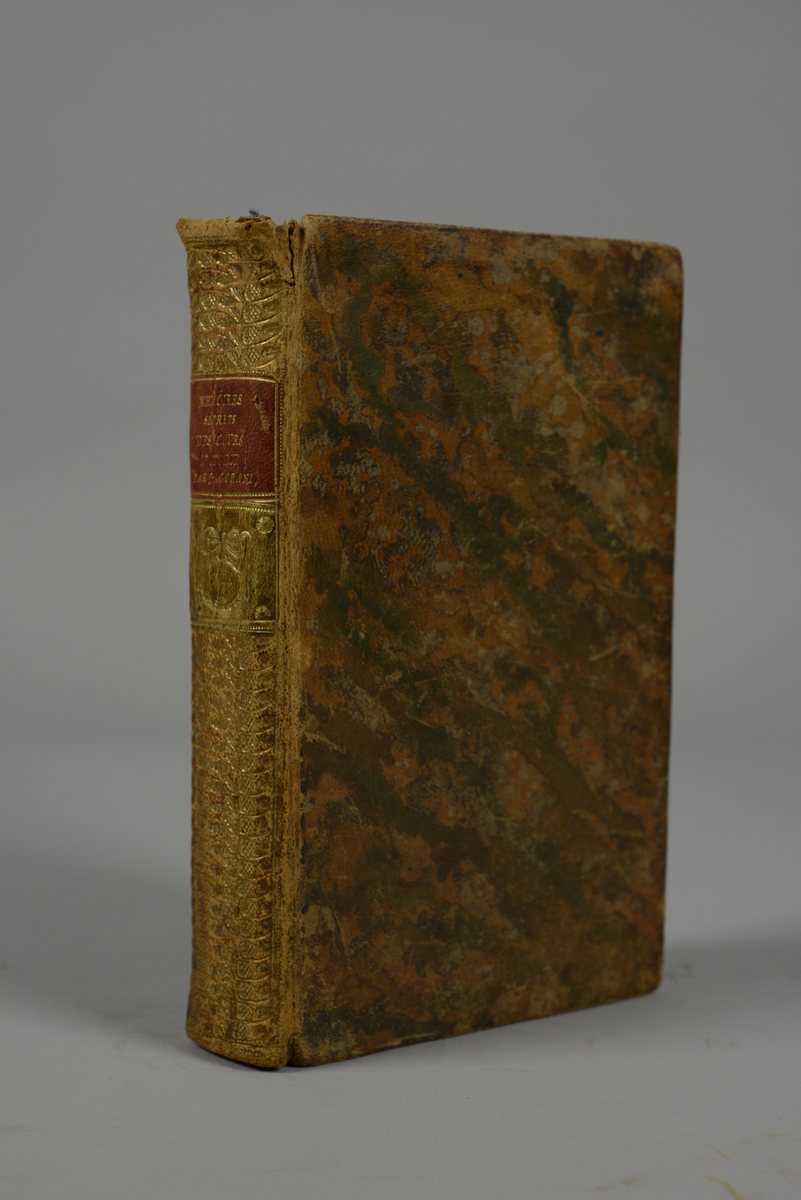 Bok, helfranskt band "Memoires secrets et critiques des cours, des gourvernemens, et des moeurs des principaux états de l'Italie", del I, skriven av Joseph Gorani, tryckt i Paris 1793.
Skinnband med blindpressad och guldornerad rygg,  rött titelfält med blindpressad titel och fält med volymens nummer. Pärmens smalsidor med präglad gulddekor. Marmorerade försättsblad och rött snitt. Bokmärke av blått siden.