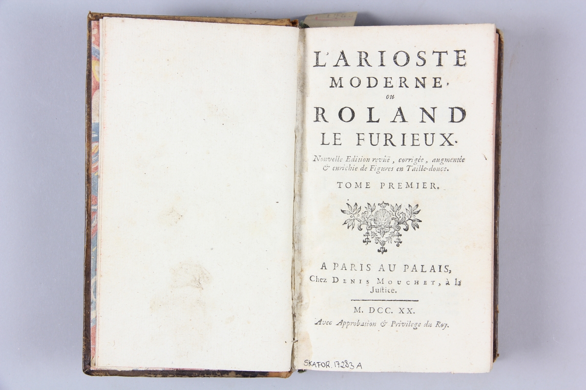 Bok, helfranskt band, "L'Arioste moderne, ou Roland le furieux", del 1, tryckt i Paris 1720.
Skinnband med rygg i fem upphöjda bind med guldpressad dekor, titelfält med blindpressad titel och fält med volymens nummer, rött snitt. Marmorerat papper på pärmarnas insida. Påklistrad pappersetikett med samlingsnummer. Illustrerad med kopparstick. Anteckning om inköp.